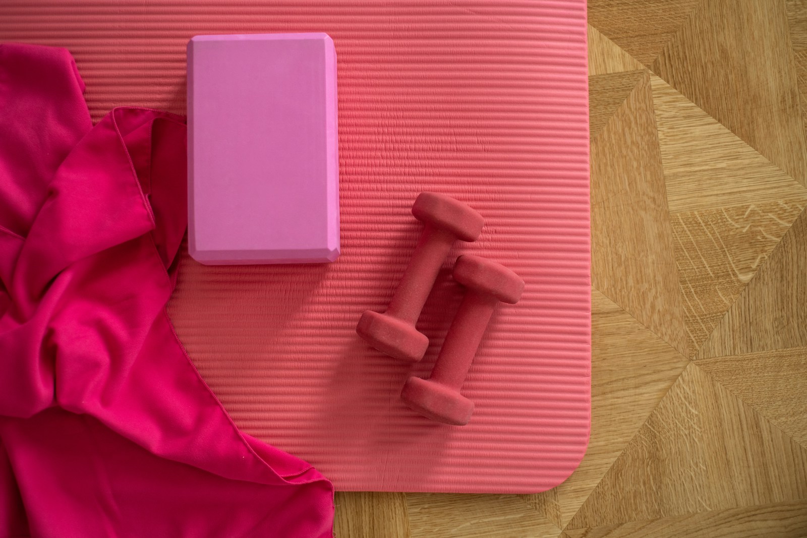 pink weights and block on yoga mat on floor