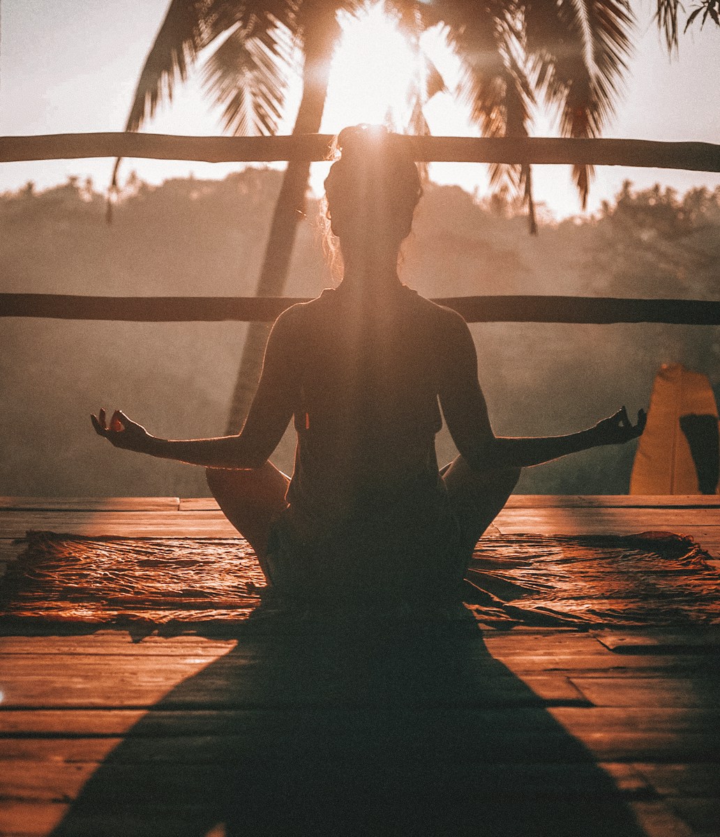 woman doing yoga meditation on brown woooden floor outside